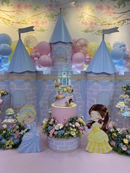 Cenografia de castelo com princesa, bolo e flores em tons pastel
