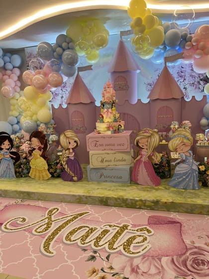 Cenografia de castelo com balões, princesas e mesa de doces