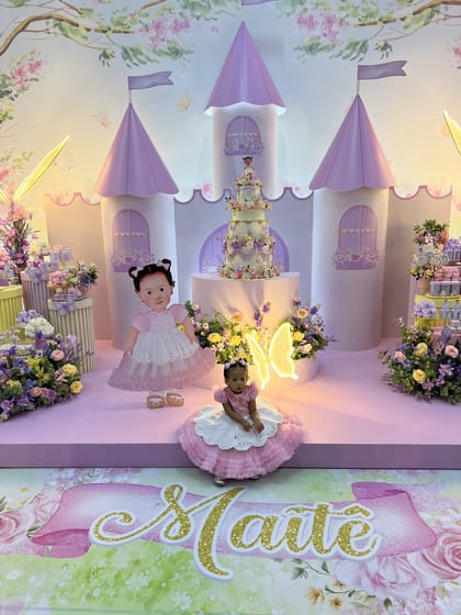 Cenografia de castelo lilás com criança, bolo e flores